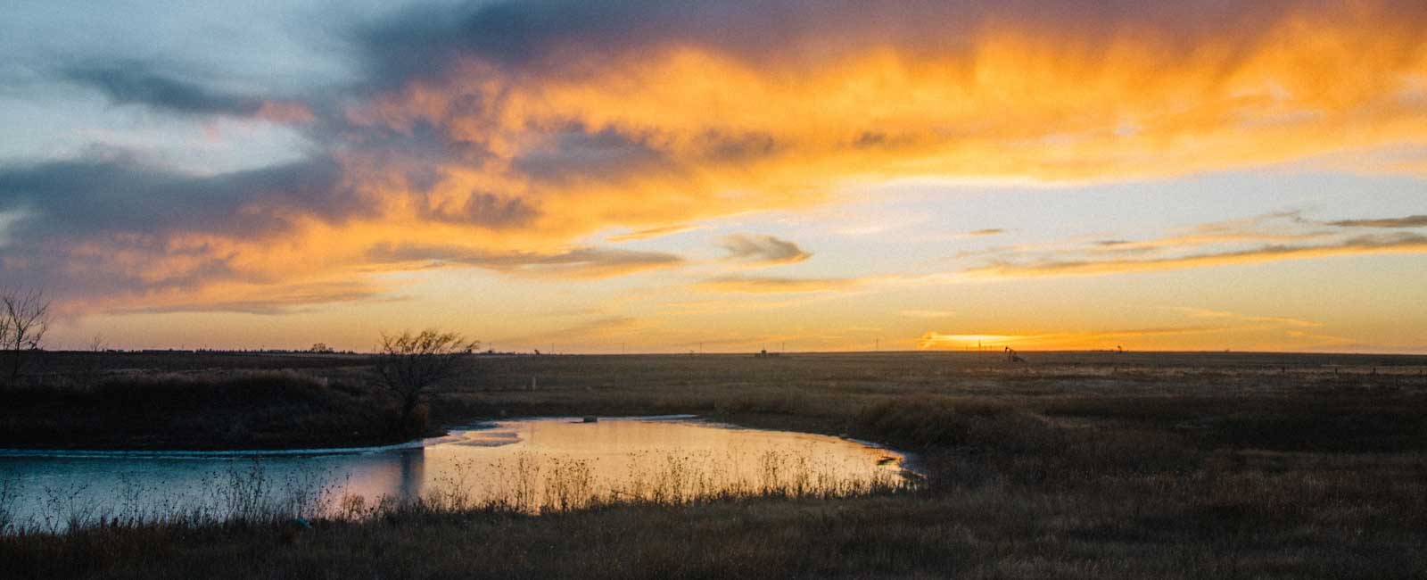 Photo of Kansas short grass prairie at sunset and a playa farm pond