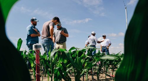 Photo of soil sensors and farmers discussing their differences